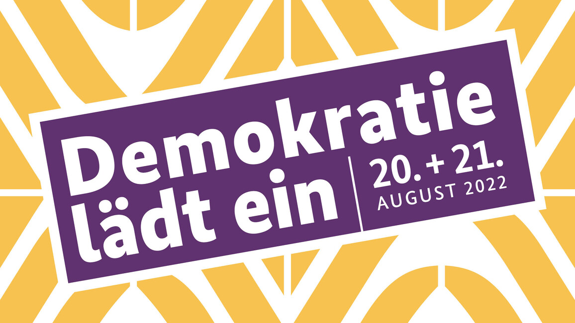 Logo des Tags der offenen Tür der Bundesregierung. In weißer Schrift auf violettem Grund steht quer über einem gelb-weißen abstrakten Muster: 