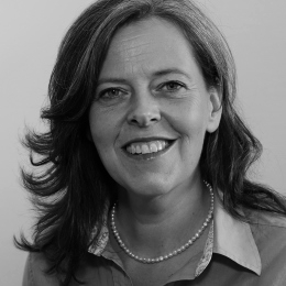 Potrait of Dr. Babette Regierer. You can see her head up to her shoulders. She is smiling at the camera. Her dark hear reaches her shoulders.